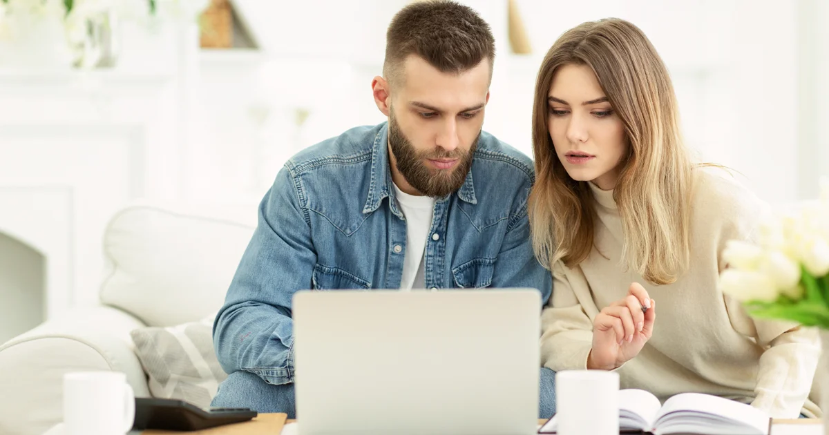 Couple gérant les dépenses avec un ordinateur portable et vérifiant la comptabilité et les factures