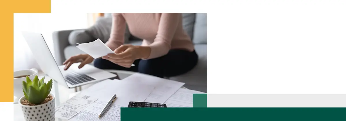 Gros plan d'une femme travaillant sur un ordinateur portable à la maison pour payer ses factures