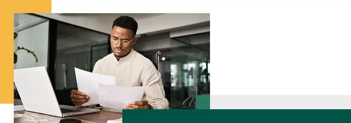 Homme d'affaires sérieux lisant un document juridique dans un dossier d'entreprise