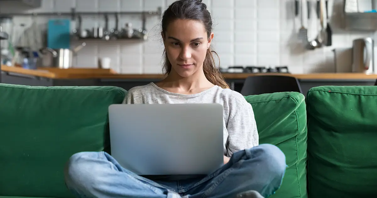 Femme sérieuse utilisant un ordinateur portable qui travaille sur un ordinateur