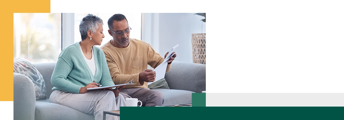 Deux collègues utilisant un ordinateur portable tout en prenant un café à la cafétéria