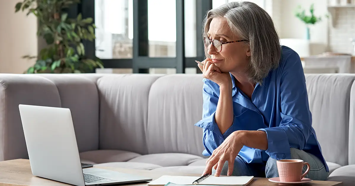 une femme regarde un webinaire de formation commerciale en ligne sur un ordinateur portable