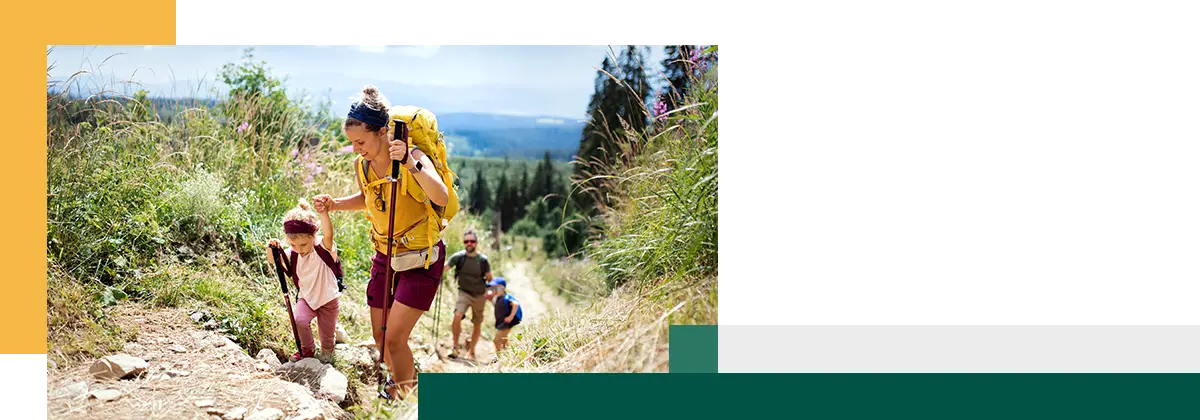 Une famille avec de jeunes enfants fait de la randonnée en pleine nature en été