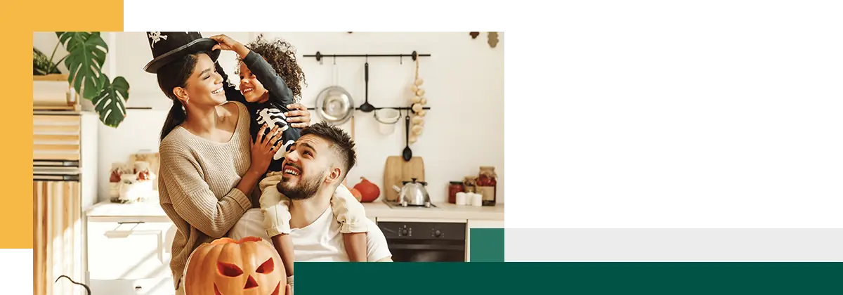 famille heureuse mère père et petit fils s'amusent et célèbrent Halloween à la maison