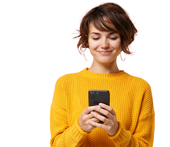 femme souriante tout en envoyant un message sur son téléphone