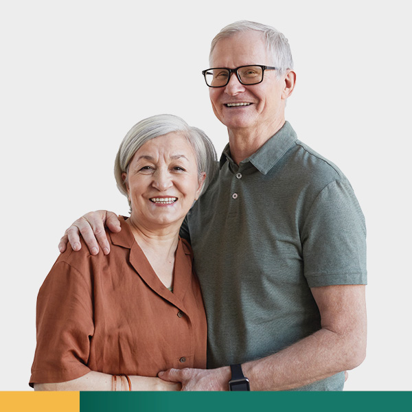Older couple smiling with arms around each others shoulders