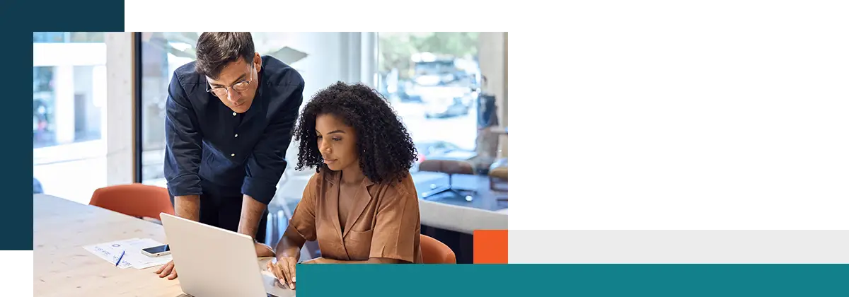 Équipe commerciale composée de deux jeunes cadres professionnels aux profils différents travaillant ensemble.