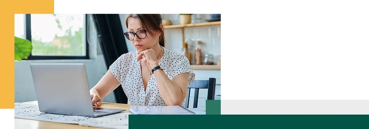 Femme concentrée prenant des décisions tout en utilisant un ordinateur