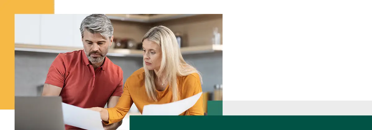 Un couple d'âge mûr assis à une table devant un ordinateur