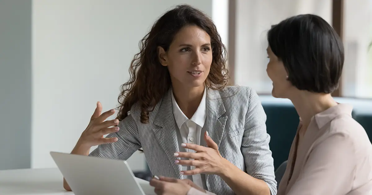 Deux femmes d'affaires assises à un bureau discutent des détails du projet