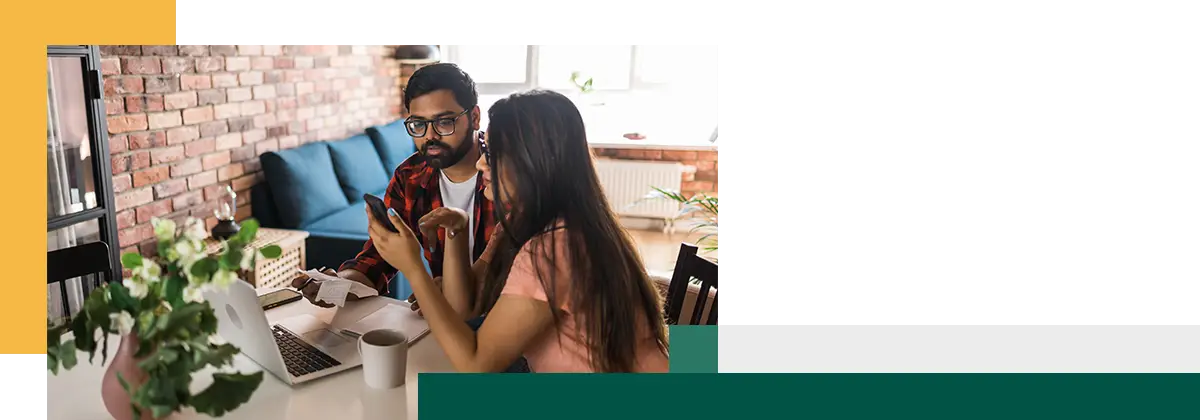 Jeune couple marié s'occupant de tâches administratives et comptables à domicile et examinant des factures papier.