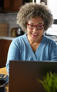 Une femme mûre gère son budget à la maison, dans la cuisine.
