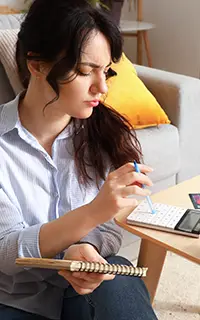 Jeune femme planifiant son budget à la maison